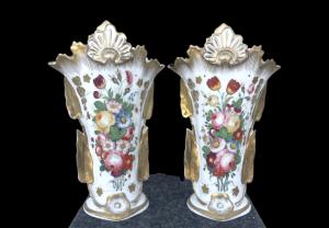 Pair of porcelain trumpet-shaped vases with leaf handles, embossed plant motifs and floral decoration. Old Paris manufactory. Louis Philippe period.