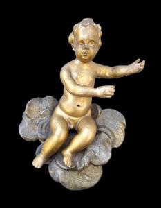 Figure of a cherub in carved and gilded wood on painted clouds. Liguria.