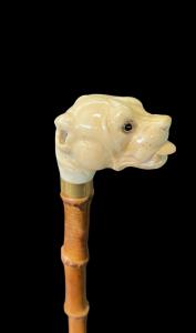 Stock mit elfenbeinfarbenem Knauf, der einen Bulldoggenkopf mit herausgestreckter Zunge darstellt.