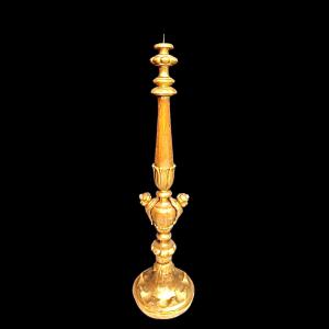 Candelabro em madeira entalhada e folha de ouro com par de mascarões, motivos vegetais e geométricos estilizados. Ligúria.