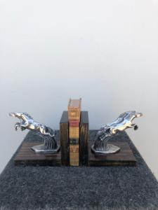 Coppia di fermalibri in metallo e legno raffiguranti cavalli stile art-d’eco’.
