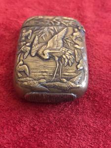 Brass matchbox with herons and birds in a lake setting in Art Nouveau style.