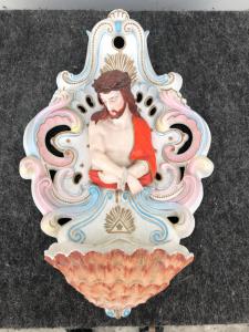 Weihwasserbecken aus Biskuitporzellan mit Rocailles-Motiven und einer Halbbüstenfigur des gefesselten Christus.