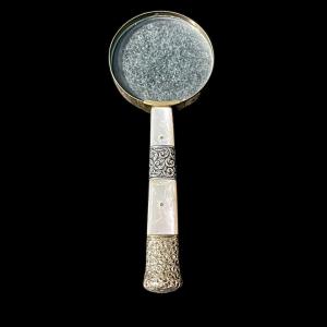 Magnifying glass in silver and mother-of-pearl with stylized plant motifs. Sterling hallmark.
