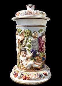 Scatola in porcellana decorata in rilievo con baccanale di cherubini. Ginori -Capodimonte.