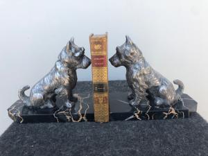 Coppia di fermalibri in marmo e antimonio raffiguranti due cani.