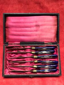 Conjunto de seis facas em metal e esmalte com decorações de troféus.