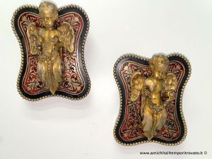 Antikes Paar geflügelter Putten aus vergoldeter Bronze mit Girlanden, auf ebonisiertem vierblättrigem Sockel mit Intarsien aus ziseliertem Messing