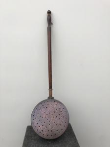 Copper bed warmer with engraved geometric patterns. Wooden handle.