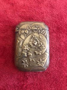 Brass matchbox with floral and Art Nouveau motifs.