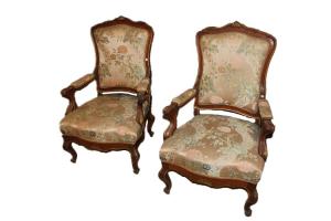 Par de poltronas francesas do século XIX, estilo Luís XV, em madeira de nogueira com bordas douradas.