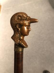 Verteidigungsstock mit Knauf aus Bronze, der einen weiblichen Kopf mit vogelartigem Helm darstellt.