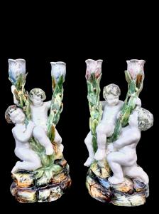 Coppia di candelieri in maiolica a due fuochi con putti. Manifattura Minghetti.Bologna.