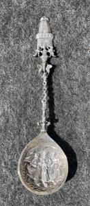 Silver dessert spoon with architectural and geometric motifs and a scene with female figures. Holland.
