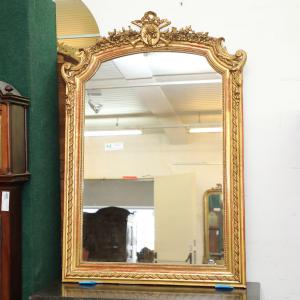 Specchiera in legno dorato con cimasa con strumenti musicali e nastro sul perimetro della cornice
