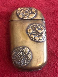 Brass matchbox with oriental floral motifs.
