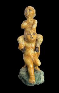 Scultura in maiolica policroma con due fanciulli che reggono un fauno.Nicola Giustiniani.Napoli.