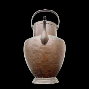 Copper pourer with ring handle and spout in the shape of a stylized bird's head.