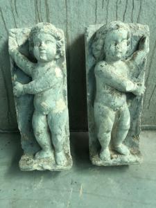 Pair of plaster sculptures depicting children.