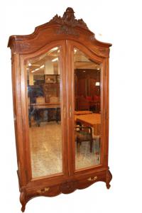 Louis Philippe style wardrobe with walnut wood and carved crest, featuring mirrors.