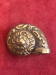 Brass matchbox in the shape of a shell with rocaille motifs.