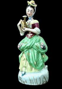 Polychrome porcelain veilleuse-teapot depicting a lady with a watering can. France.