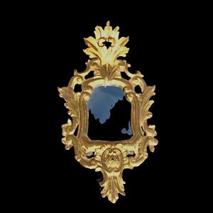 Espelho em madeira esculpida com motivos vegetais, rocailles e folha de ouro. Veneza.