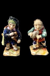 Pareja de figurillas de porcelana policromada que representan 'gobbetti' o caramogi músicos. Manufactura Ernst Bohne Söhne. Turingia.