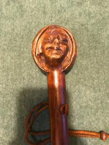 Bastone con pomolo in legno raffigurante testa di figura femminile.