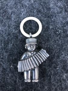 Silberne Babyrassel in Form eines Akkordeonspielers. Europa.
