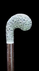 Bastone con pomolo in argento cesellato  con motivi floreali.