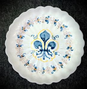 Alzata baccellata in maiolica a decoro ‘compendiario’ con motivi vegetali stilizzati sulla tesa e giglio ‘mediceo’ sull’umbone.Deruta.