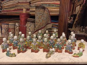 Important collection of 'Laughing Boys', famille rose, Qianglong dynasty, late 18th century. The kneeling figure wears a jacket with floral motifs and holds a Ru Yi scepter. The Chinese "Feng Shui Ruyi" scepter symbolizes prosperity and good auspice.