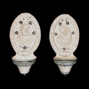 Paar Weihwasserbecken aus Fayence mit Reliefdarstellung von Jesus und Maria sowie einem Rand mit Pflanzenmotiven, Veneto.