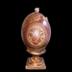 Coconut powder box engraved with trophy scenes, weapons and grotesque figures. Silver details. Base added for display. France.