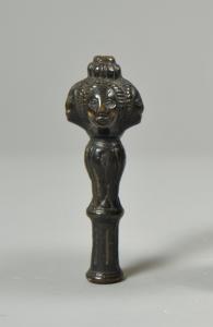 Antikes Bronzeendstück mit dunkler Patina und vier Gesichtern