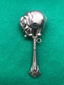 Chocalho de prata para bebê com figura de elefante.