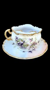 Porcelain mustache cup with molded rocaille motifs and floral decoration.