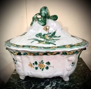 Terrina de faiança com relevos rococó, decoração floral e pega em forma de fruta. Fabricação de Cerreto Sannita.