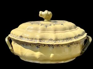 Zuppiera in maiolica giallo ocra, lobata, con decorazioni a volute rocaille. Francia.