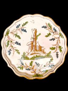 Alzata in maiolica decorata con motivi vegetali stilizzati ed elementi architettonici. Pavia.