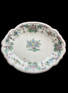 Oval majolica plate with border decorated with 'little landscapes' and a flower basket in the center. Ferniani manufacture, Faenza.