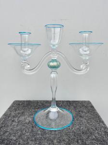 Candeliere in vetro trasparente leggermente iridato con dettagli azzurri.Presenta  forma umana stilizzata a due bracci.Manifattura Seguso.Murano.