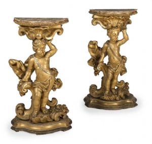 Fabulous pair of gilded and carved wooden consoles with putti, marble tops. 53 cm. 17th century