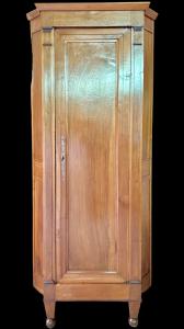 Eckschrank aus massivem, hellem Nussbaumholz.