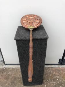Embossed copper bed warmer with a floral and bird design. Wooden handle.