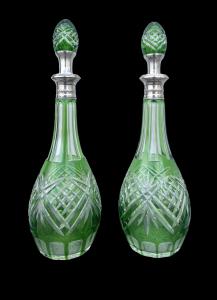 Coppie di bottiglie in cristallo verde molato con collo in argento.