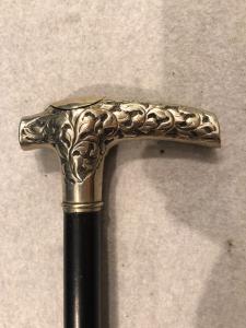 Pilgerwanderstock mit Metallknauf und einer Heiligenfigur aus Silber in einem Knochenbehälter.