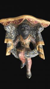 Mensola angolare in legno intagliato e dipinto con figura di paggio moro seduto su festoni.