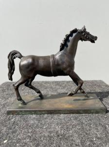 Bronzeskulptur mit Sockel, die ein Pferd darstellt.